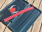Offenes FswStudio-Oboenrohretui Rose für 20 Rohre mit gemaltem Mond-und-Rose-Deckel und rotem Silikonband.