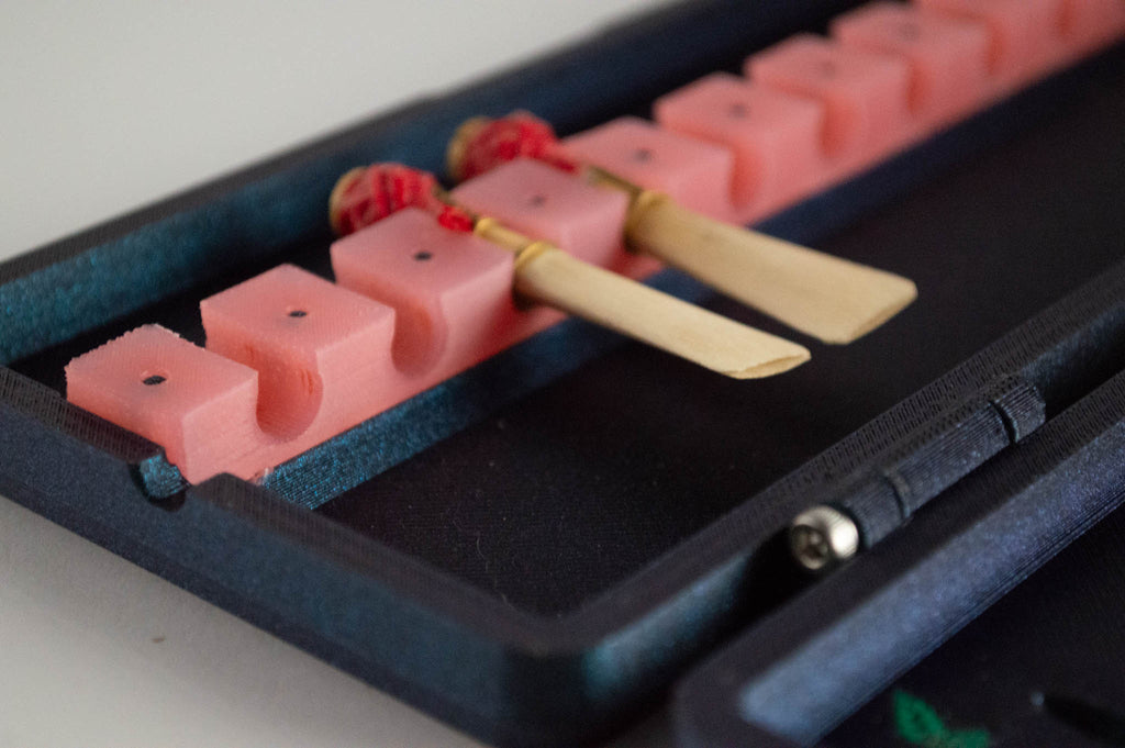 Open FswStudio Rose bassoon reed case showing bassoon reeds held in a pink silicone strap