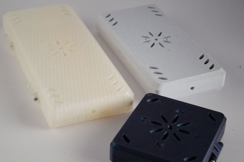 3D-printed FswStudio contrabassoon reed cases in cream, marble and navy showing the honeycomb texture and engraved flower pattern