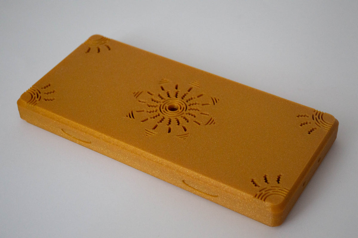 Étui à anches imprimé en 3D doré, avec une gravure soleil décorative sur le couvercle.